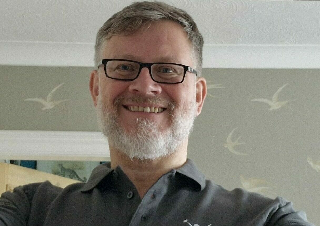 Richard holding a fostering moments photo frame, for foster care fortnight