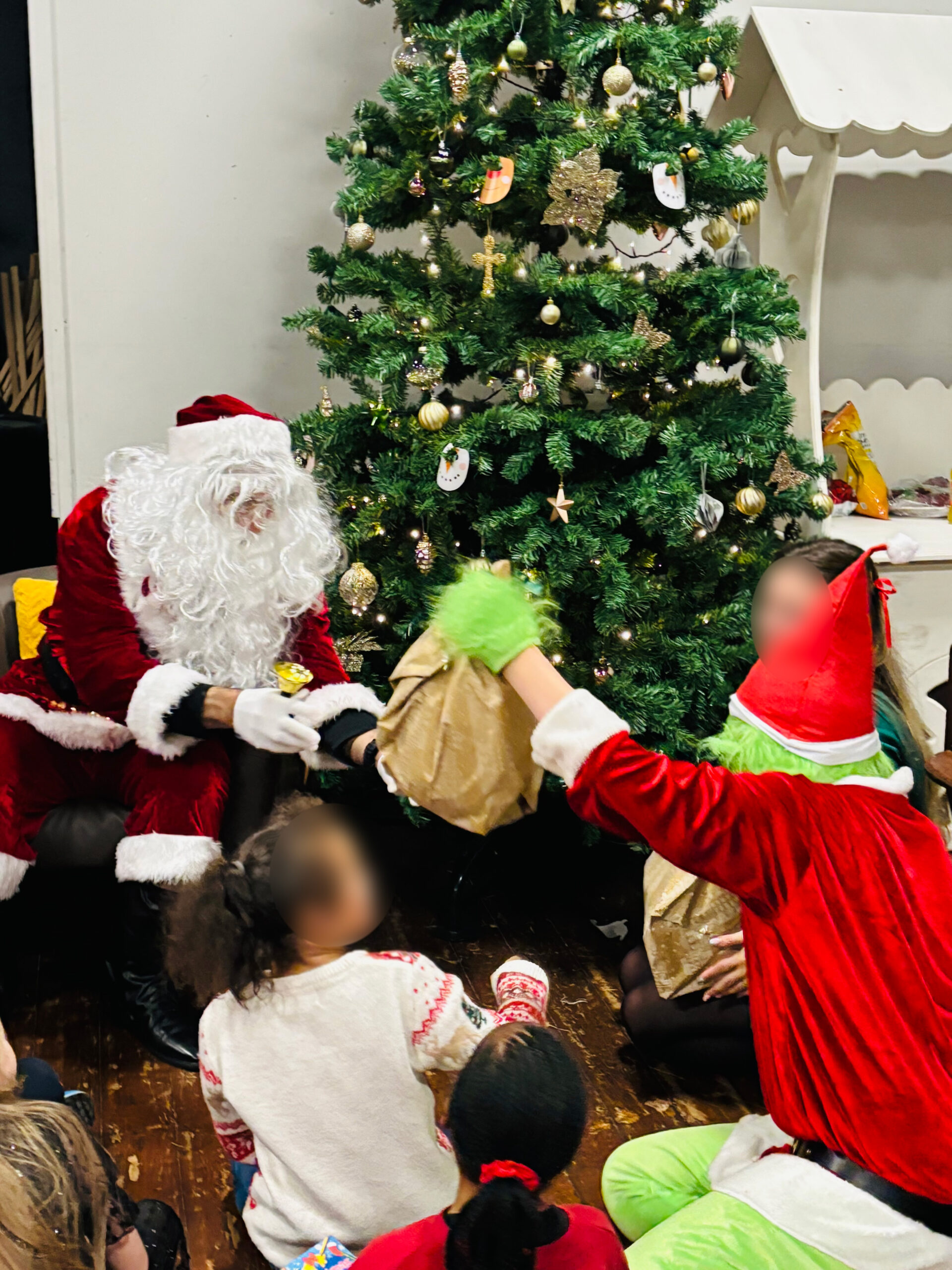 Children meeting santa by a Christmas tree