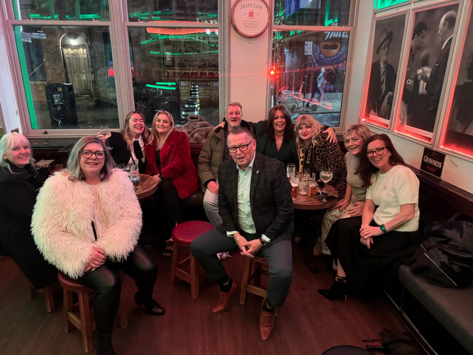 Ten foster carers smiling at a Christmas meal