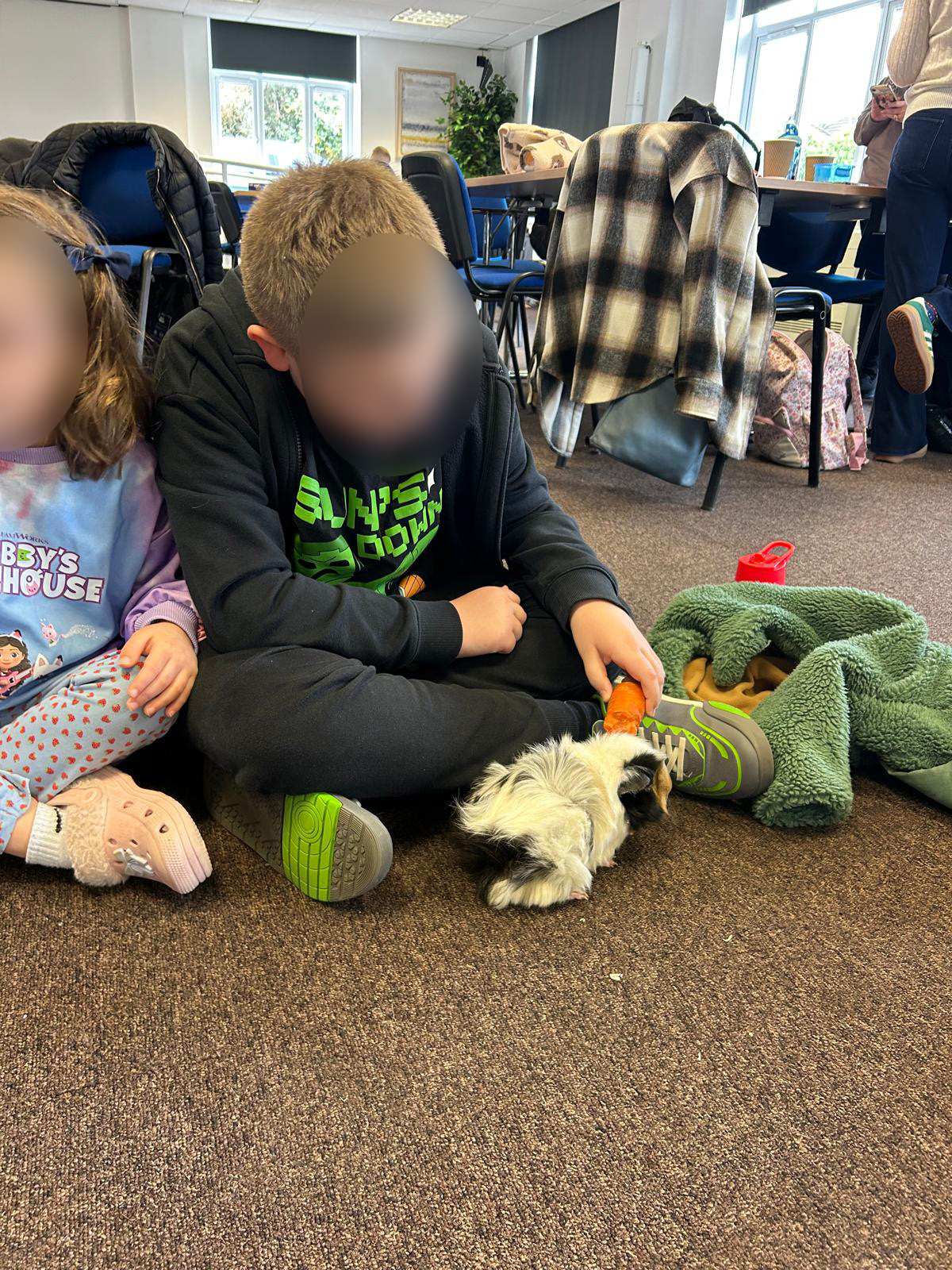 TACT young people feeding a guinea pig