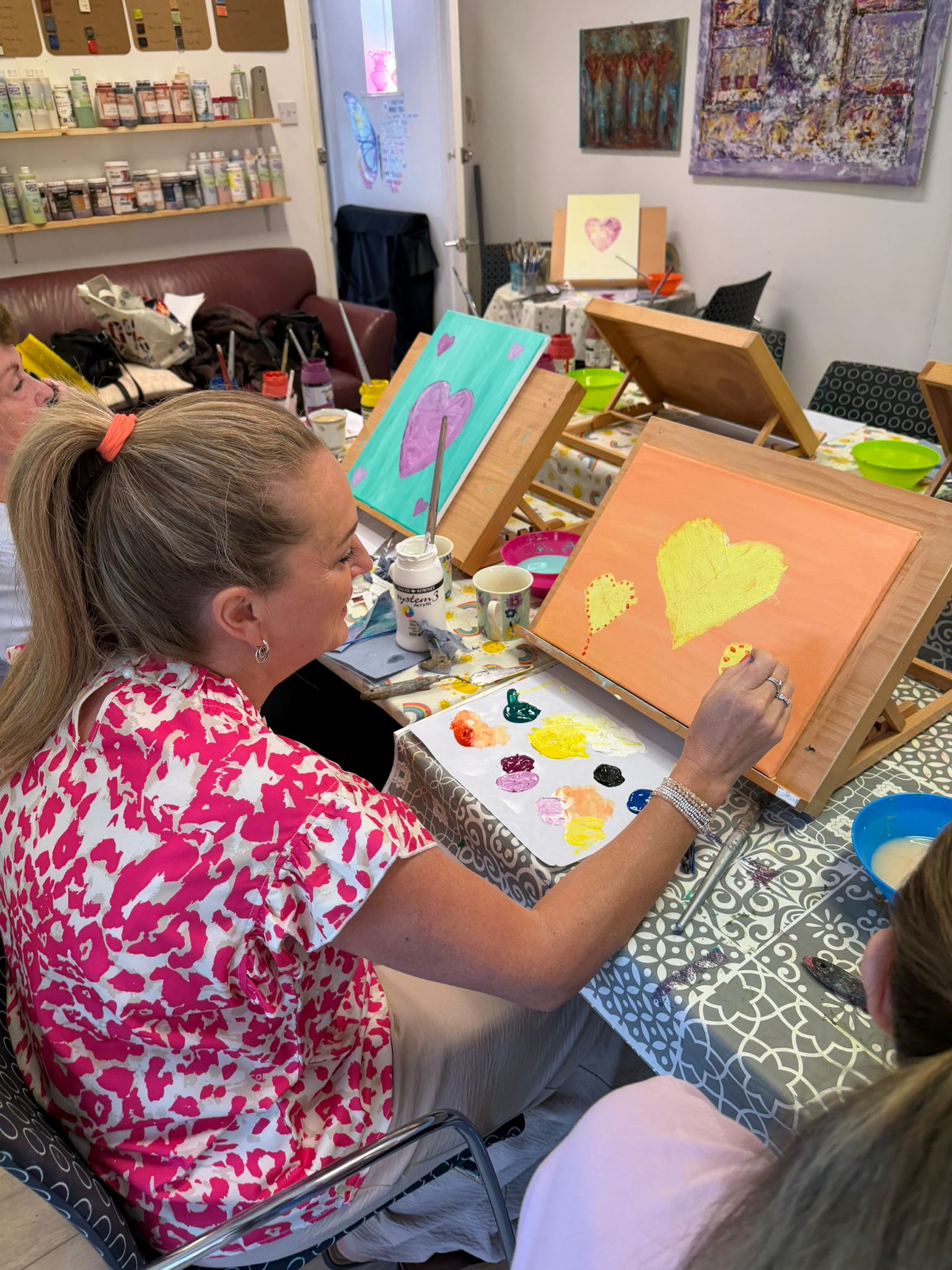 A TACT foster carer painting a yellow heart