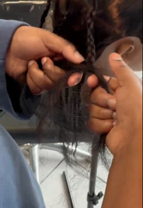 A TACT young person learning how to plait hair