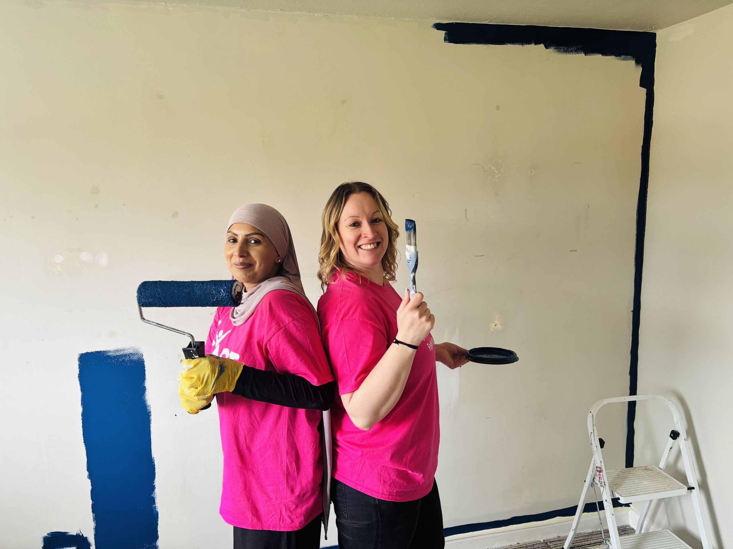 TACT staff Saj and Helen getting ready to paint a wall