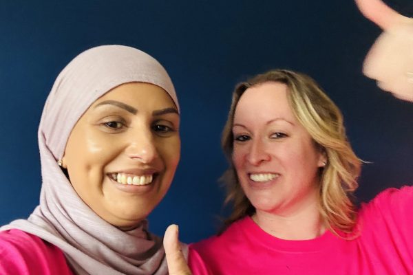 TACT's Saj and Helen giving a thumbs up after painting a wall