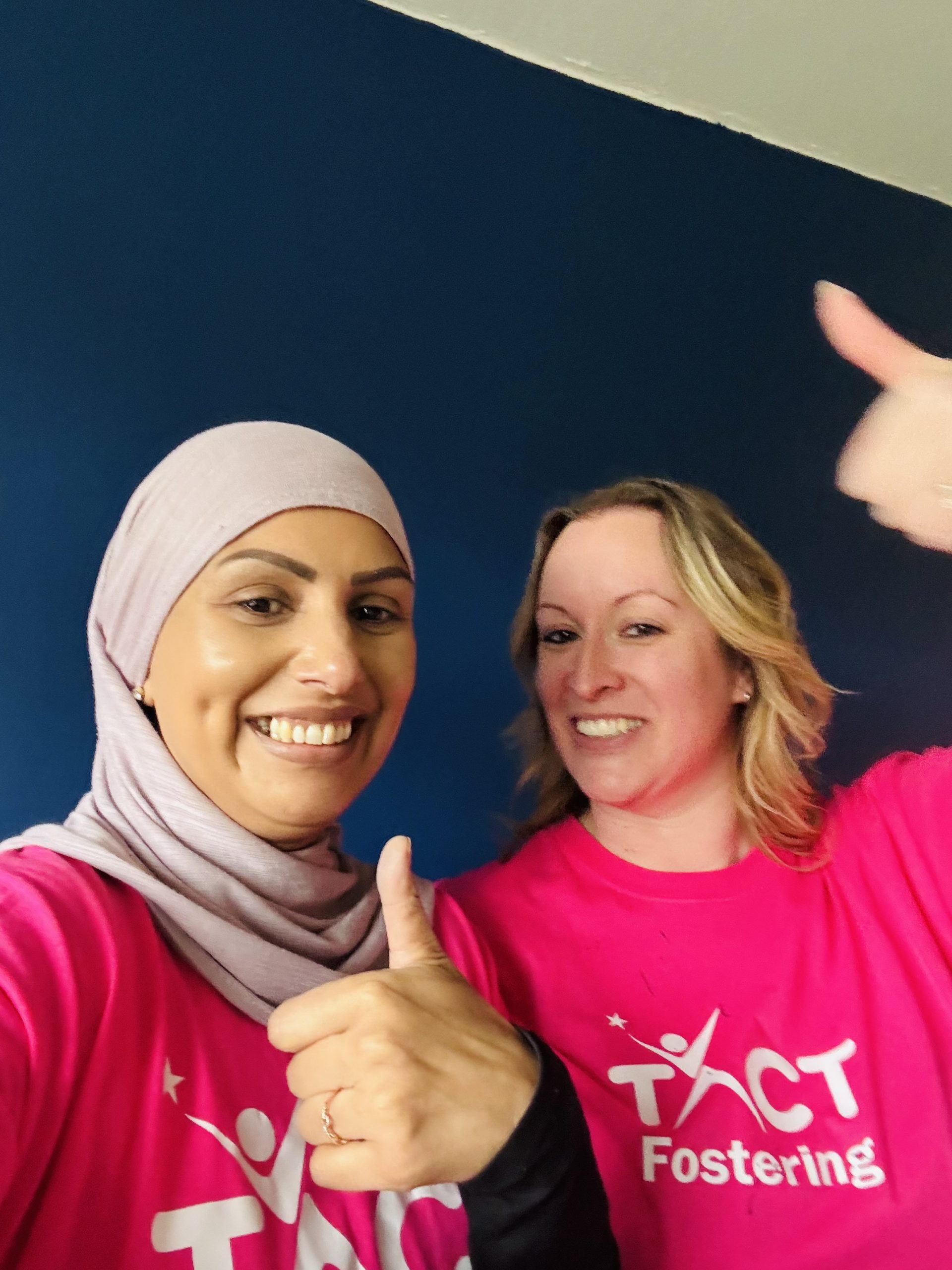 TACT's Saj and Helen giving a thumbs up after painting a wall
