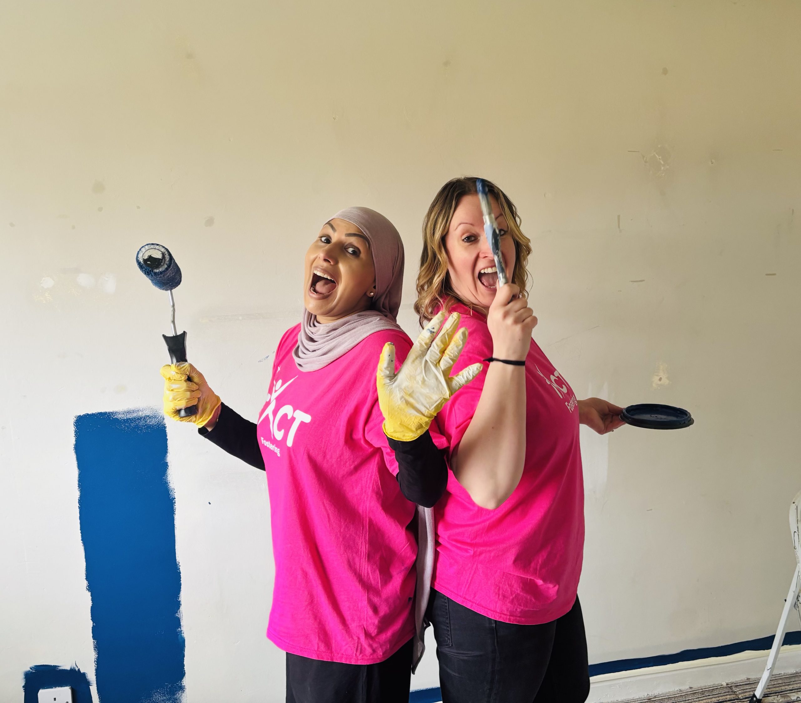 TACT's Saj and Helen smiling whilst painting