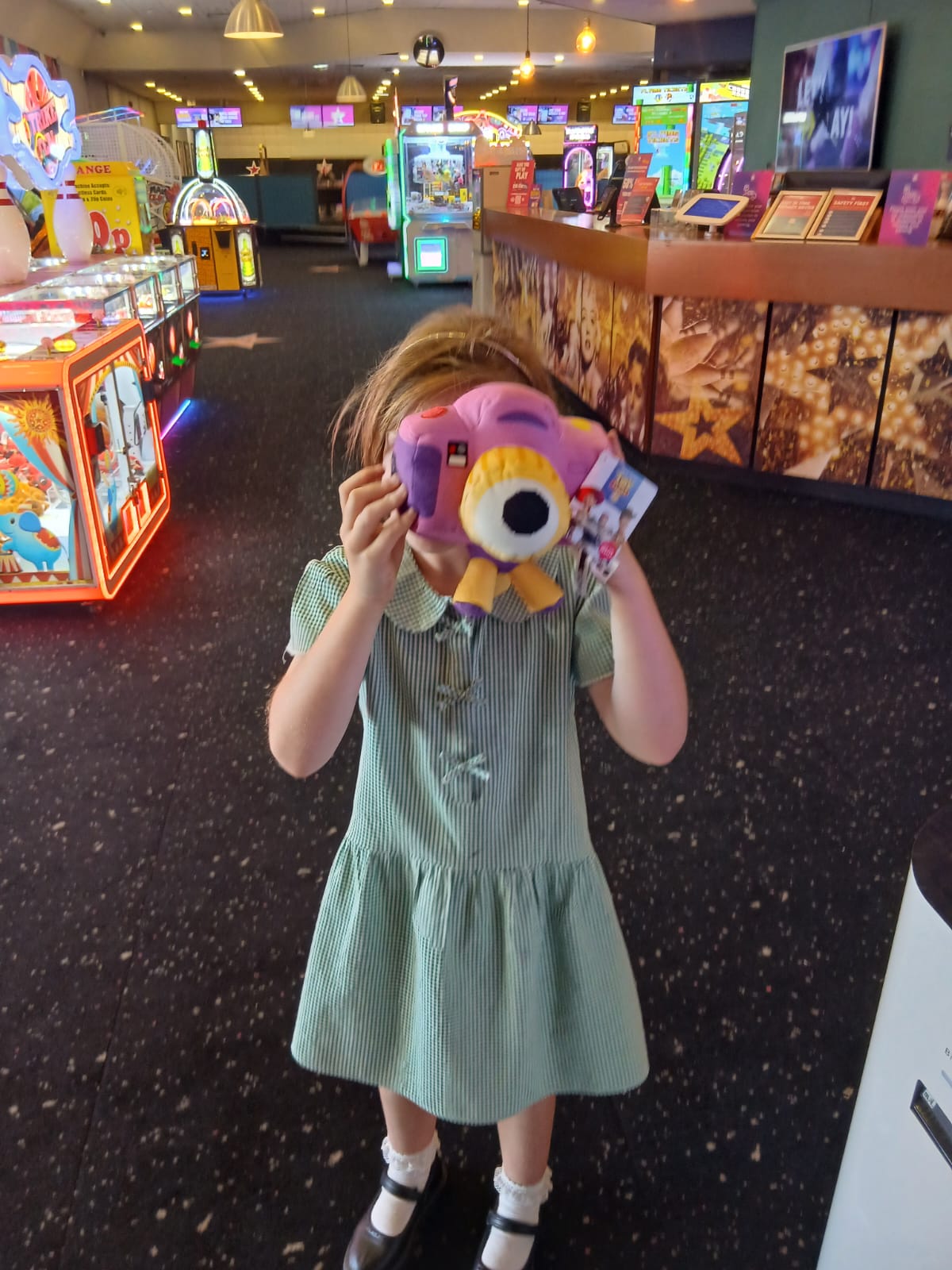 A young person holding a soft toy in front of their face